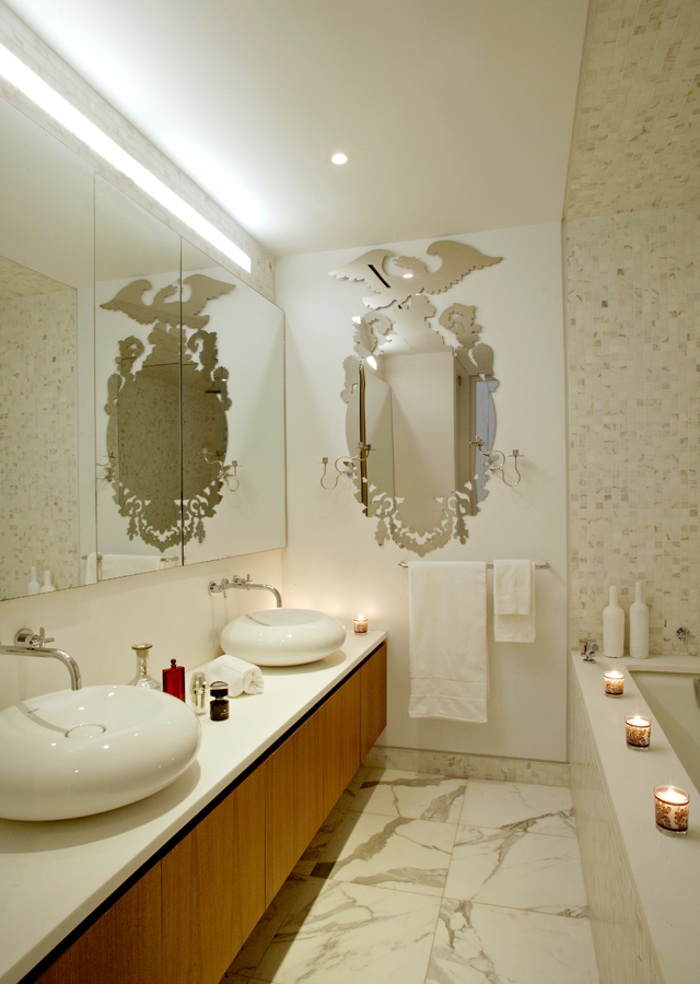 Marble bathroom with mirrors and a vanity at New York's Waterfall Mansion, with discreet audio